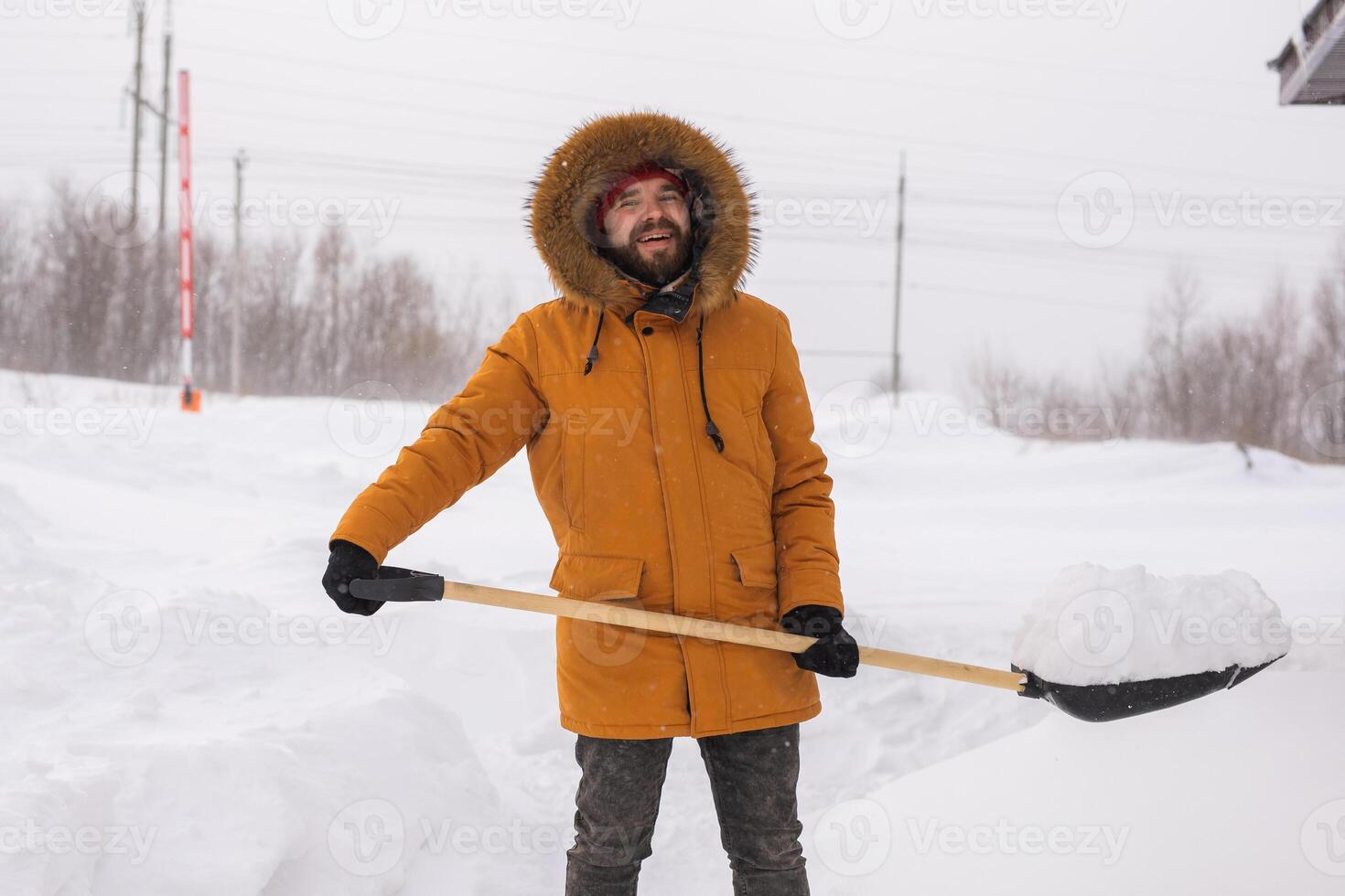 Man is clearing the snow near house and on staircases hovelling at the winter season. Winter storm and season specific photo
