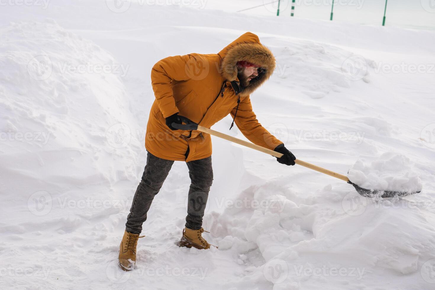 Man cleaning snow from sidewalk and using snow shovel. Winter season photo