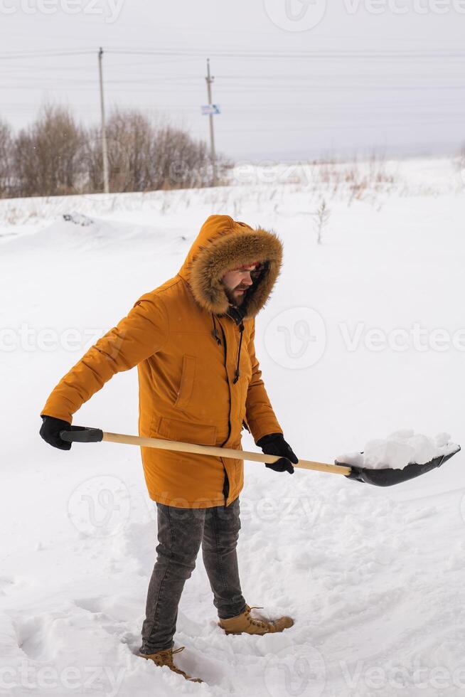 Man removing snow and ice from the sidewalk in front of house. Winter season photo