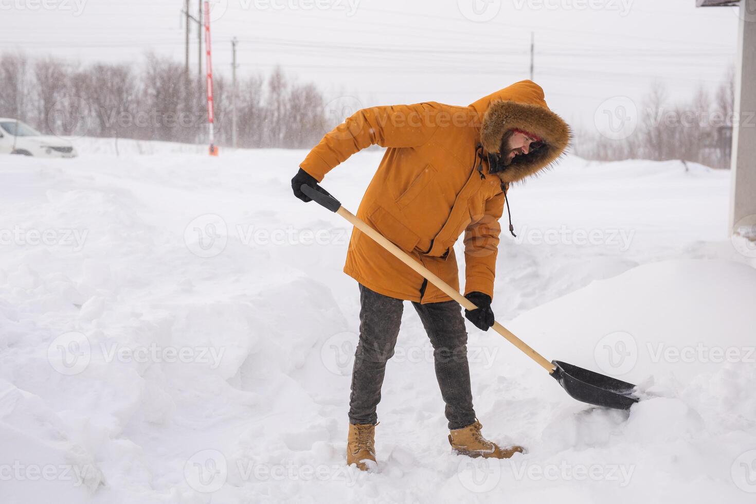 Man cleaning snow from sidewalk and using snow shovel. Winter season photo