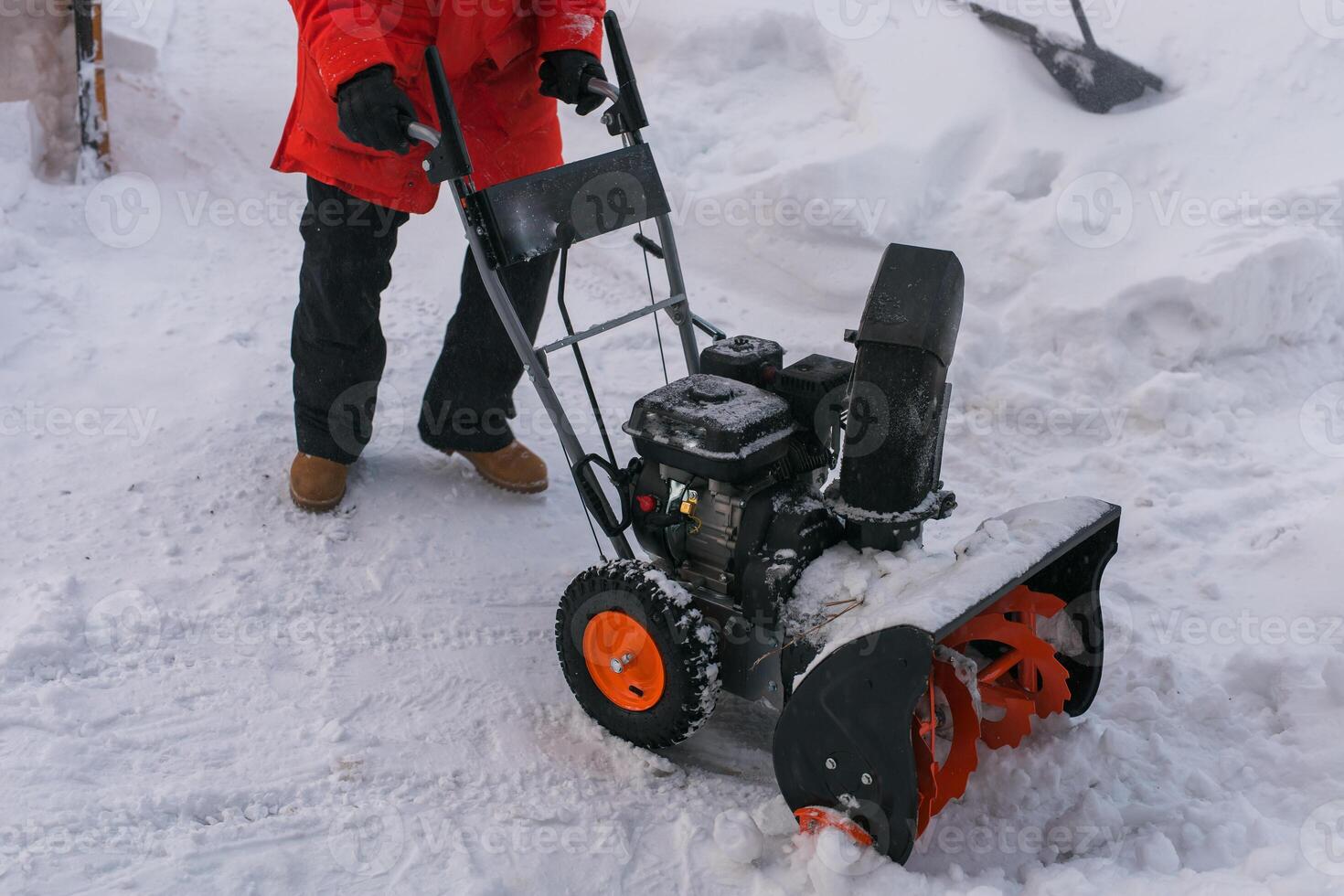 A man clear snow from backyard with snow blower close-up. Winter season and snow blower equipment close-up photo