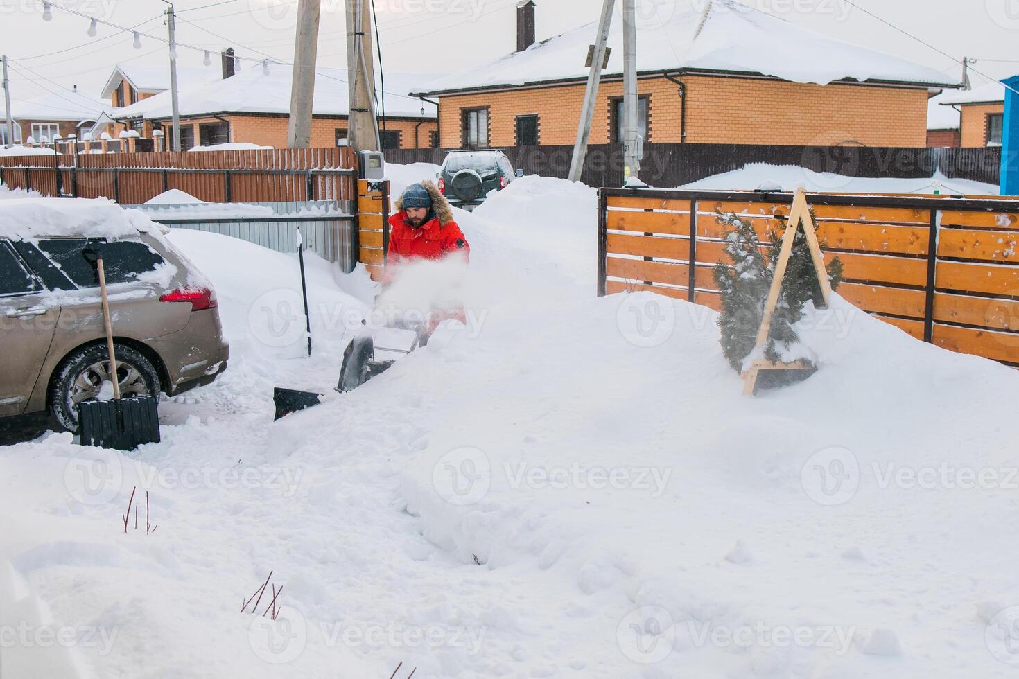 A man clear snow from backyard with snow blower. Winter season and snow blower equipment photo