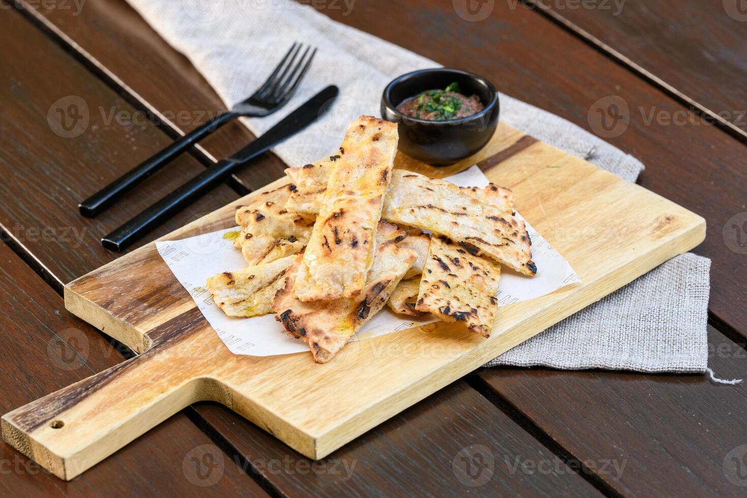 A wooden cutting board with some bread on it photo