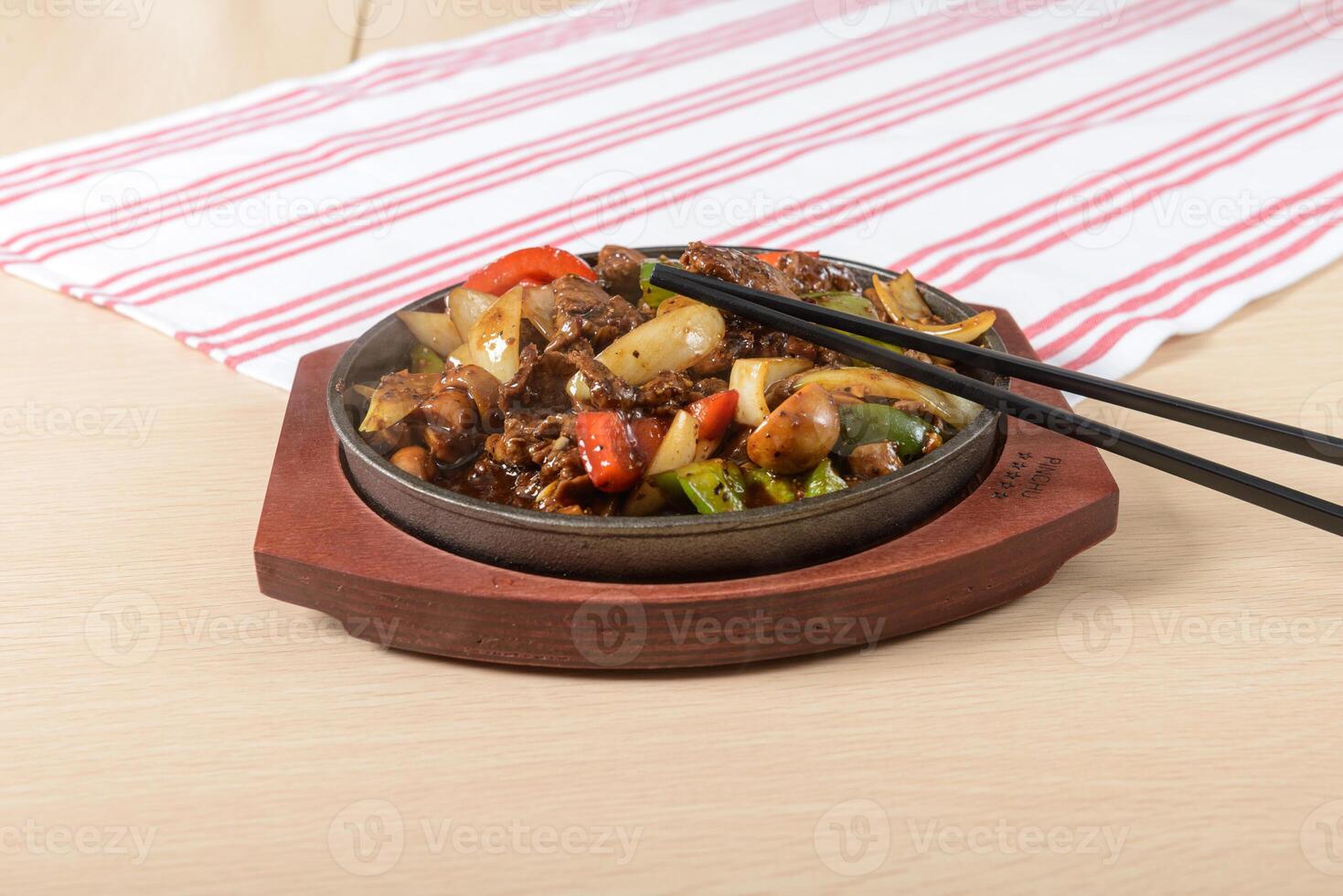 A bowl of food with chopsticks on a table photo