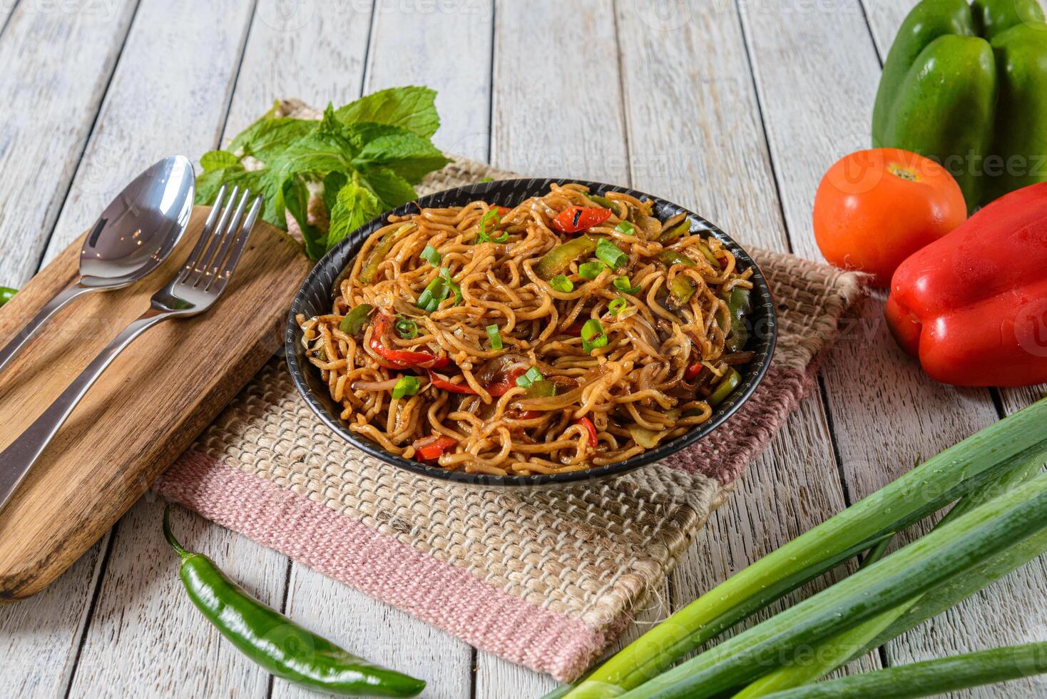 A bowl of noodles and vegetables on a table photo
