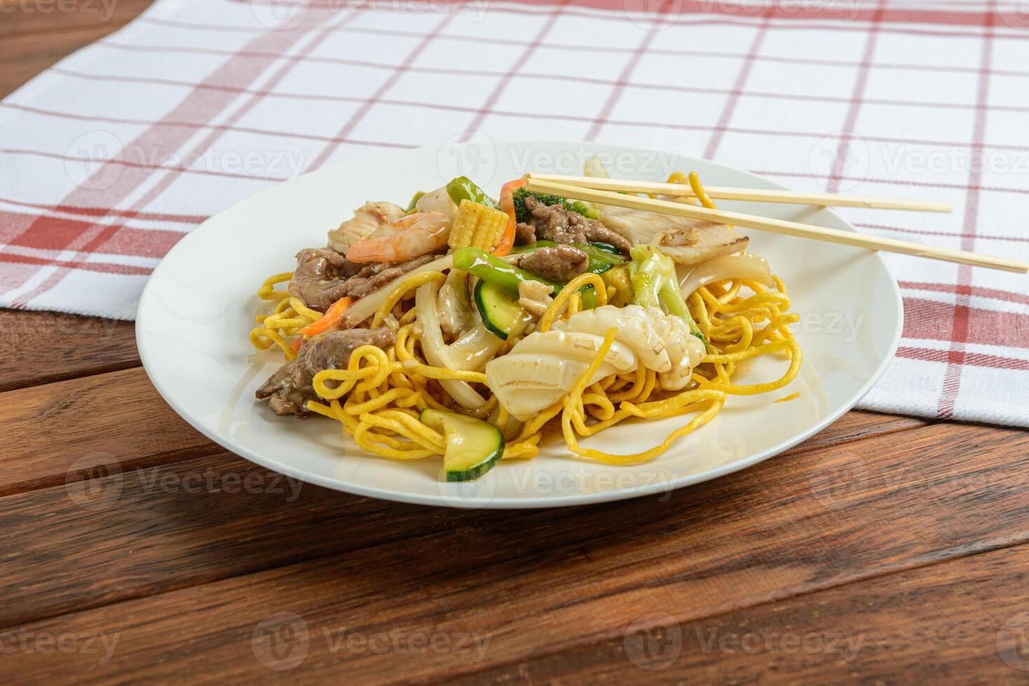 A plate of noodles and meat on a table photo
