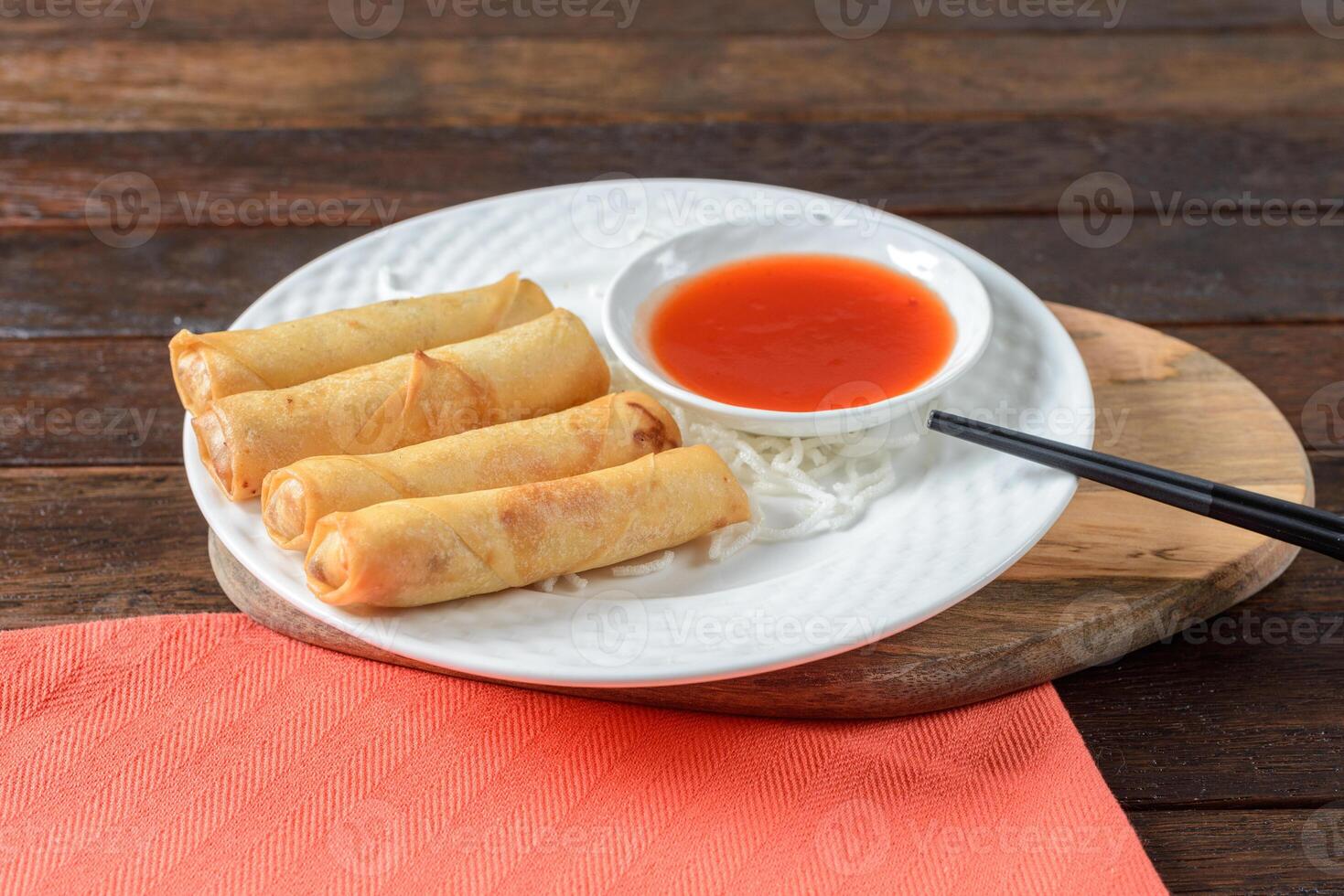 Chinese spring rolls with dipping sauce on a white plate photo