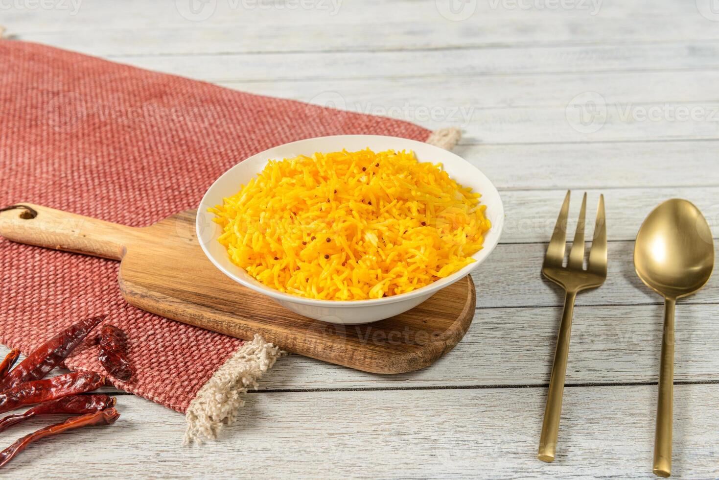 Indian rice in a bowl with spoons and red chilli photo