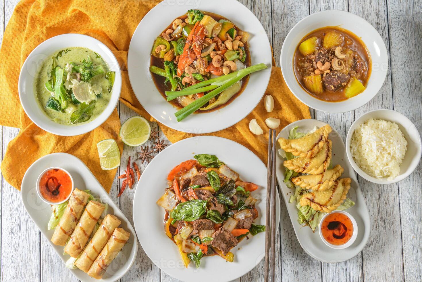 Various plates of food on a table with a bowl of soup photo