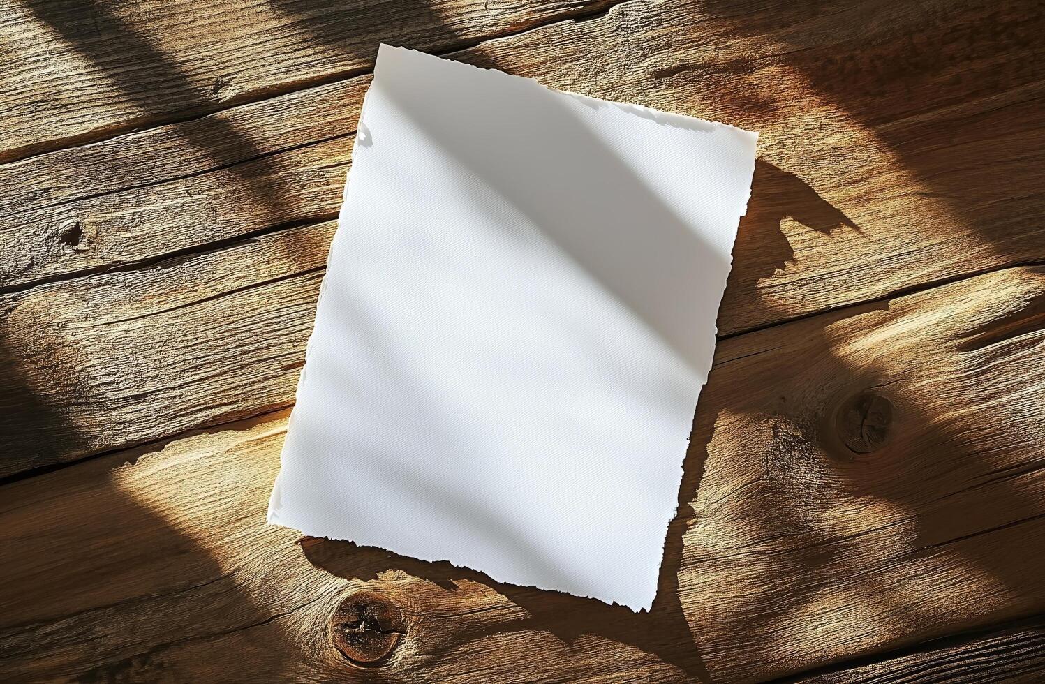 Blank sheet of paper resting on rustic wooden table with shadows from overhead light photo