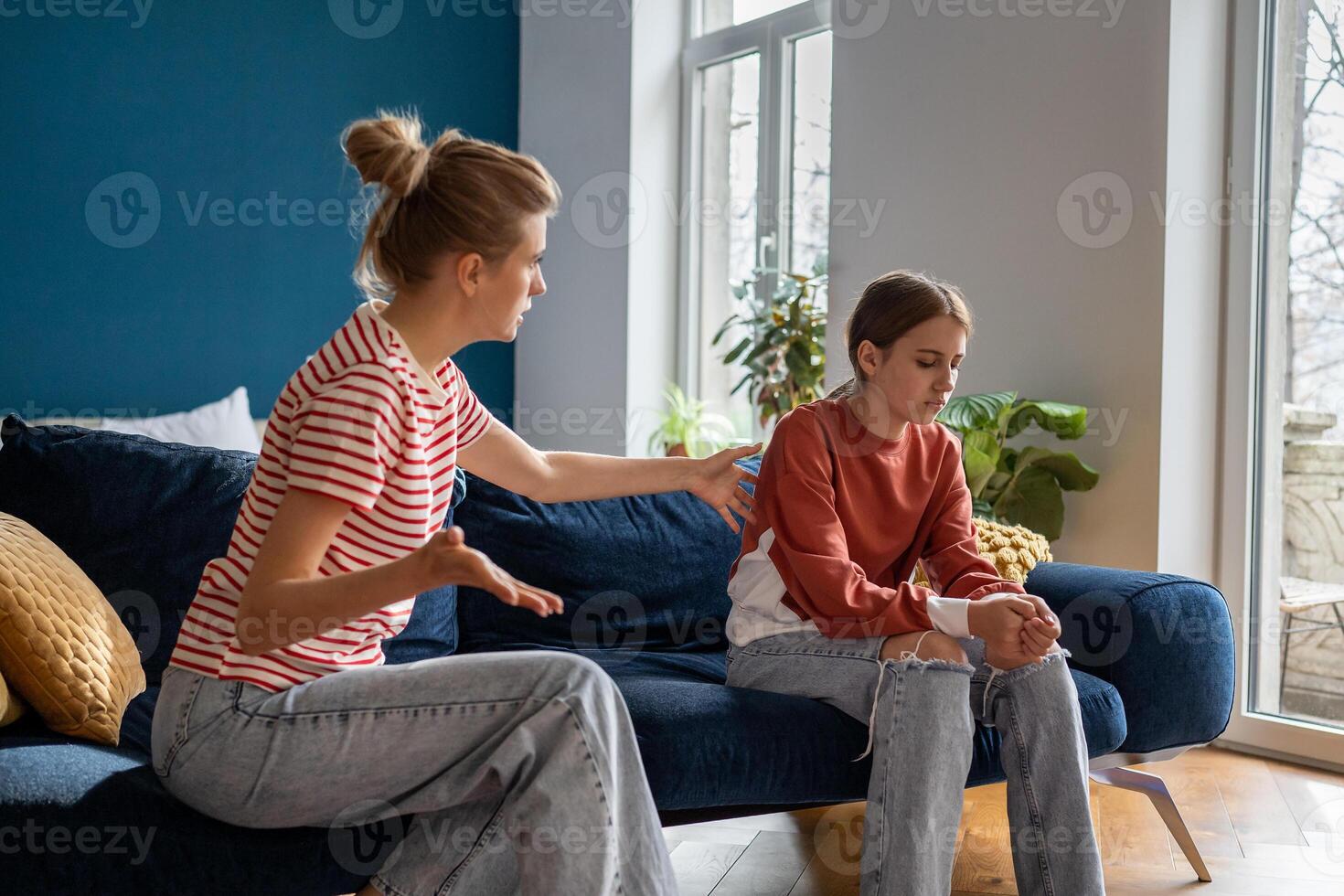 Young woman loving mother trying to speak with upset depressed teen daughter photo