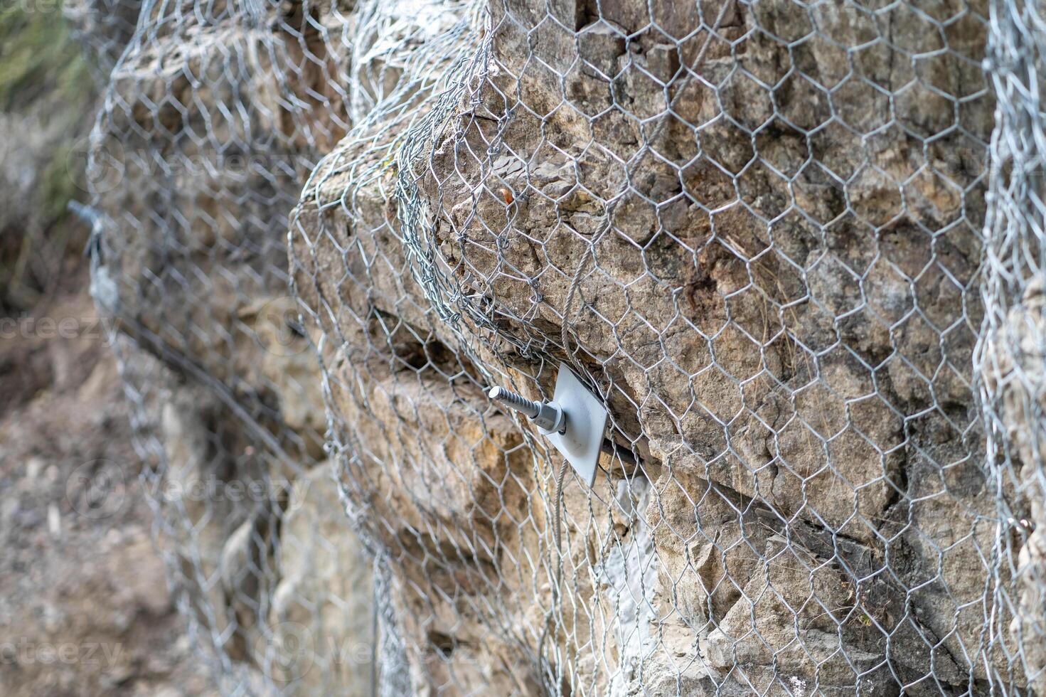 Landslide and rock sliding prevention in Turkey, reinforcing mountain slope with metal mesh. photo