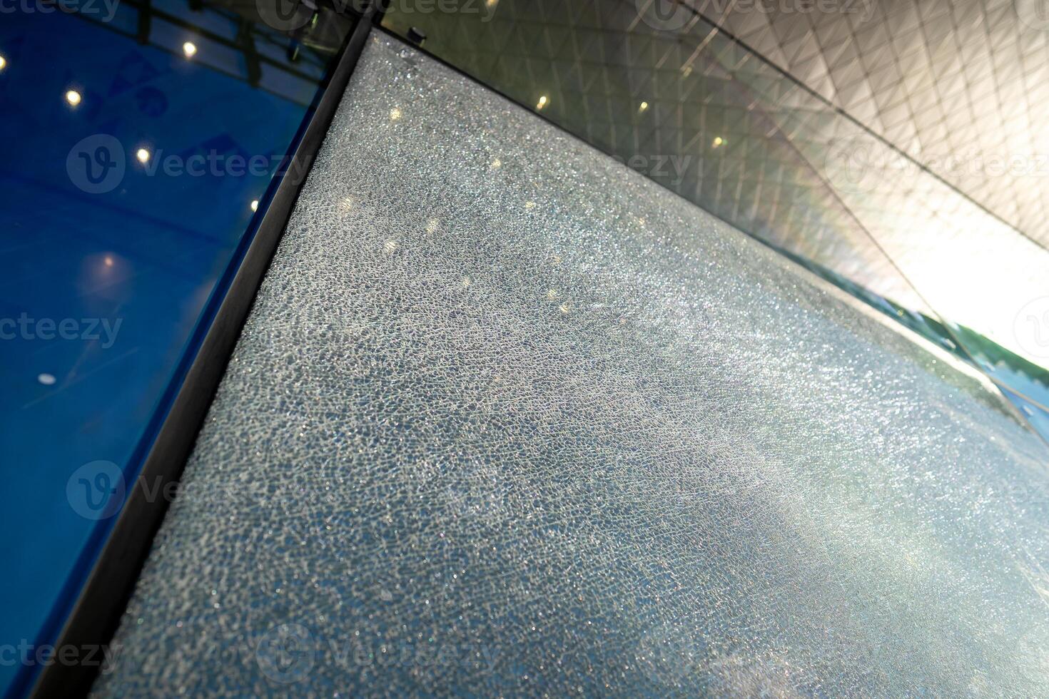 Shattered facade glass panel with visible cracks, no falling. Smart glass technology, damage control photo