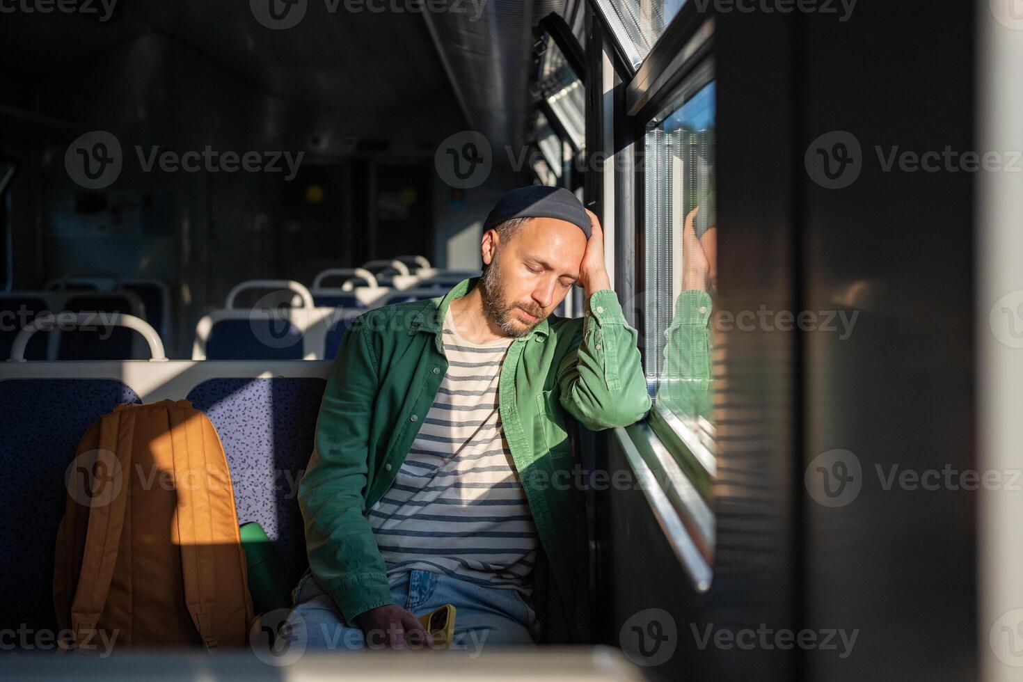 Weary man dozes off on train while commuting in empty car. Early rise for business trip, overload photo