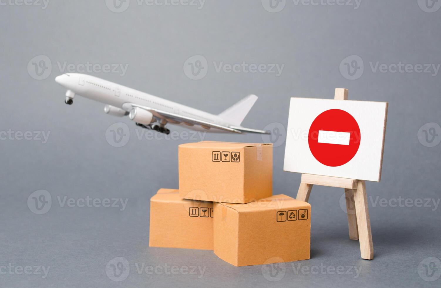Cargo plane with boxes and an easel with a restriction sign. Restrictions on export of scarce and medical goods for the period of border closure quarantine and pandemic. Obstacle to globalization photo