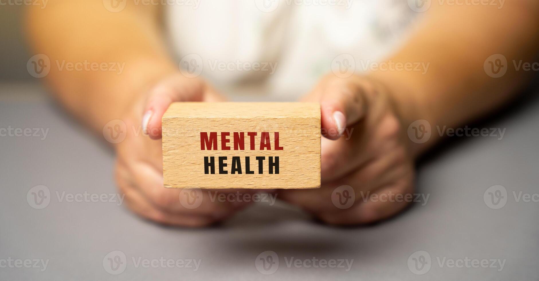 Mental health on wooden blocks in female hands. Emotional, psychological, and social well-being, influencing cognition, perception, and behavior. Depression, anxiety disorder photo