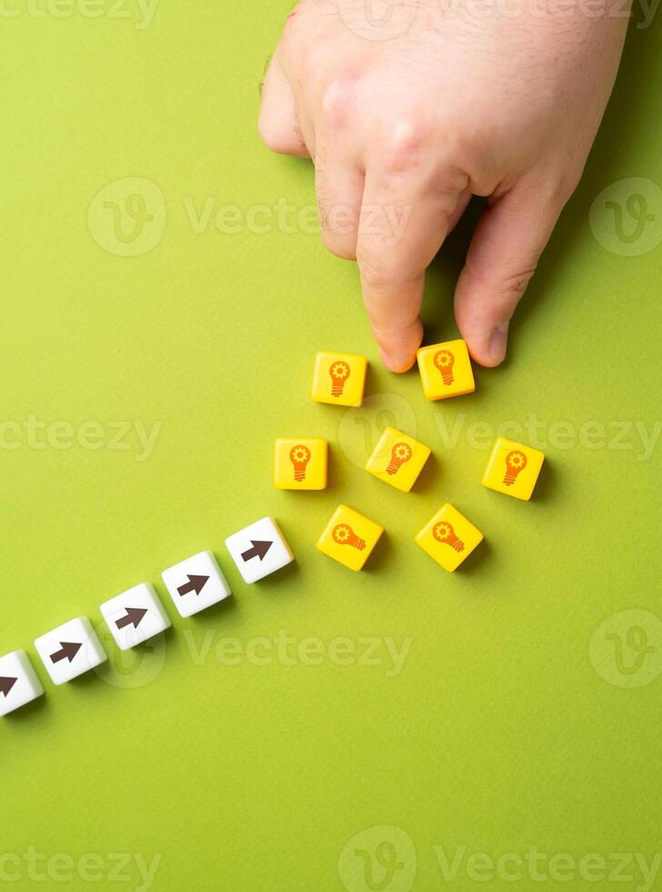 Hand puts blocks with light bulbs ideas. Concept of technological development and ingenuity. Patents. Advancing research, intellectual property protection, and groundbreaking developments. photo