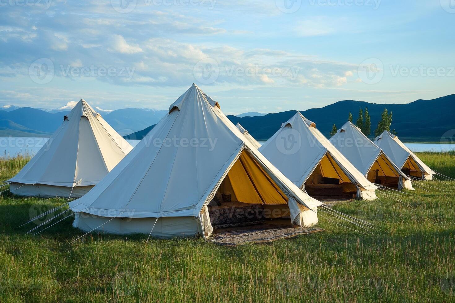Glamping tents standing in a row near the lake and mountains photo