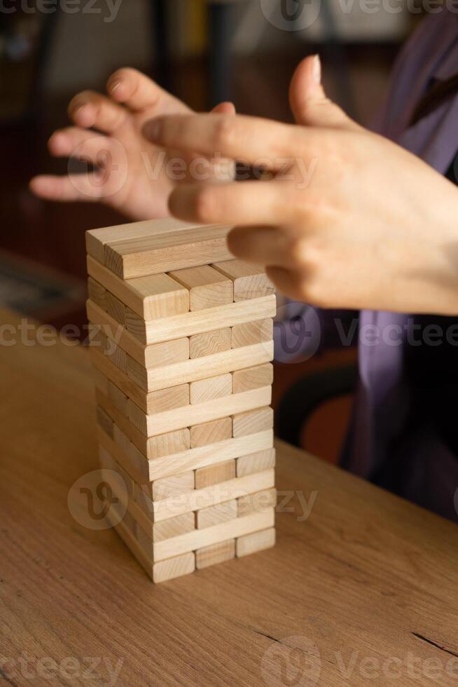 Building Team Skills Wooden block tower with hands in action symbolizes teamwork photo