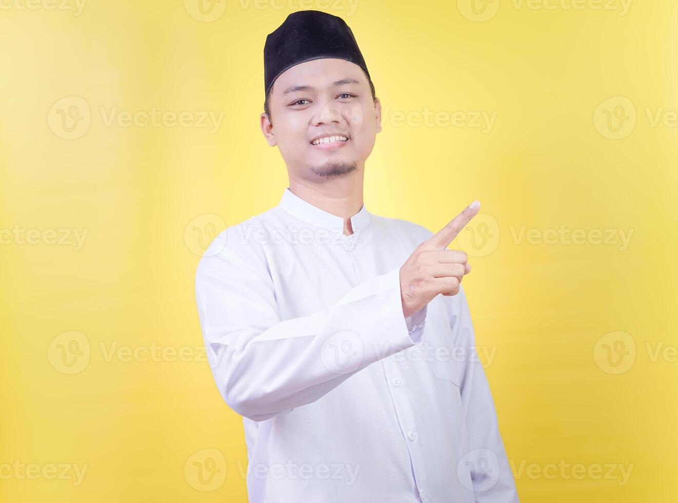 a man in a white shirt and hat pointing at something photo