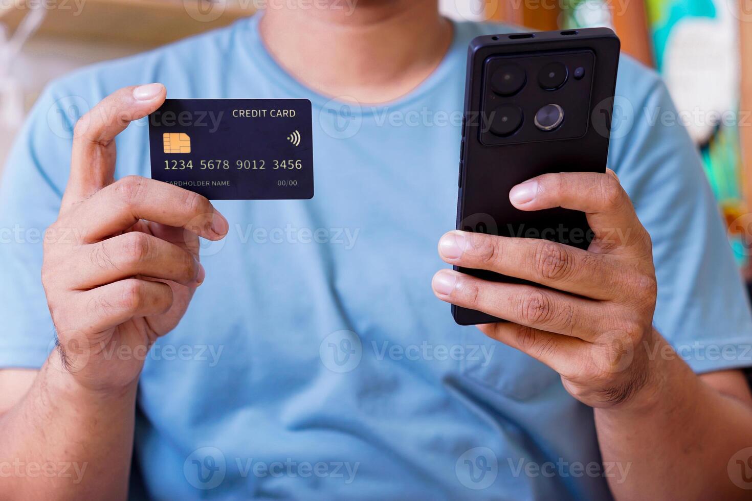 A person holding a smartphone and a credit card, engaging in online transactions photo
