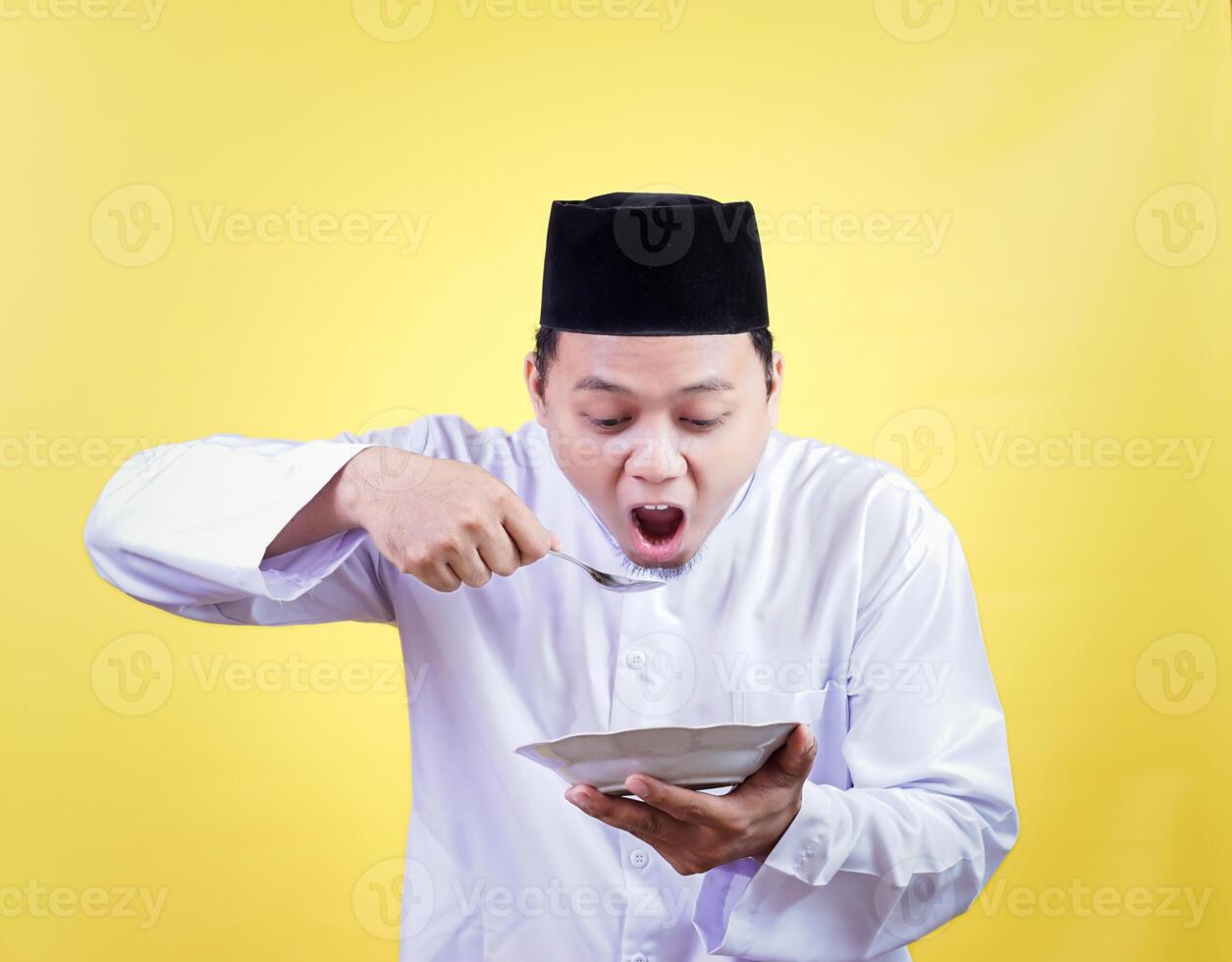 a man in a white shirt and hat eating a bowl of food photo