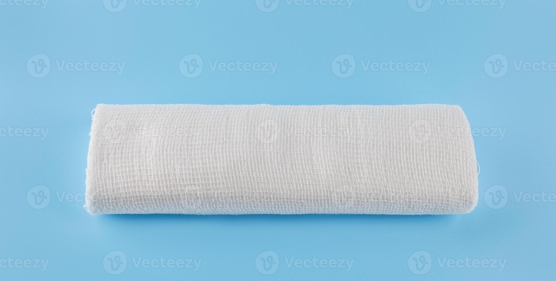 Gauze medical bandage on a blue background. Roll of bandage. photo