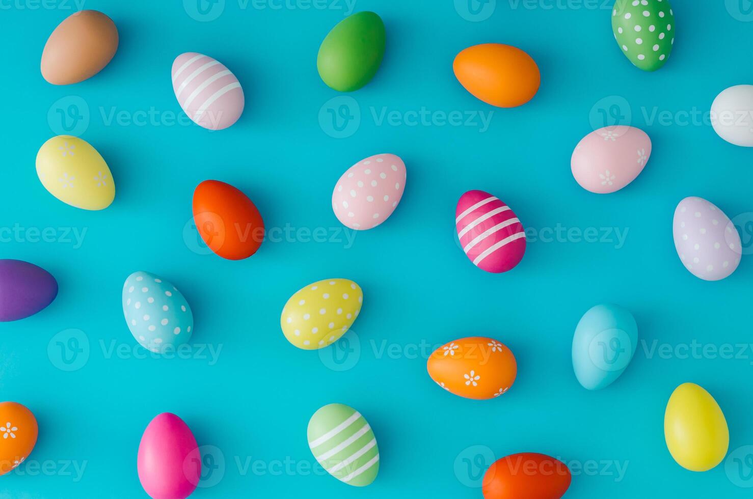 Colorful pattern composition made of various colored Easter eggs on light blue background. Minimal Easter concept. Creative festive spring holiday backdrop. Easter aesthetic. Flat lay, top of view. photo