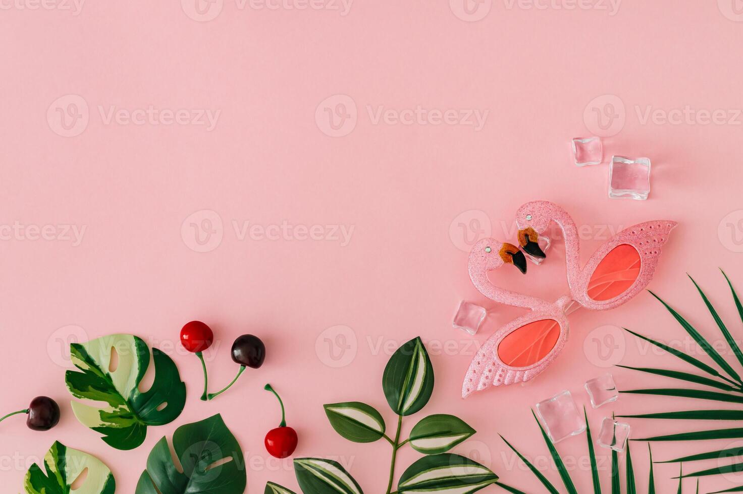 Trendy layout with tropical leaves, pink flamingo party sunglasses, ice cubes and red cherries on pastel pink background with copy space. Creative summer aesthetic concept. Beach party idea. Flat lay. photo