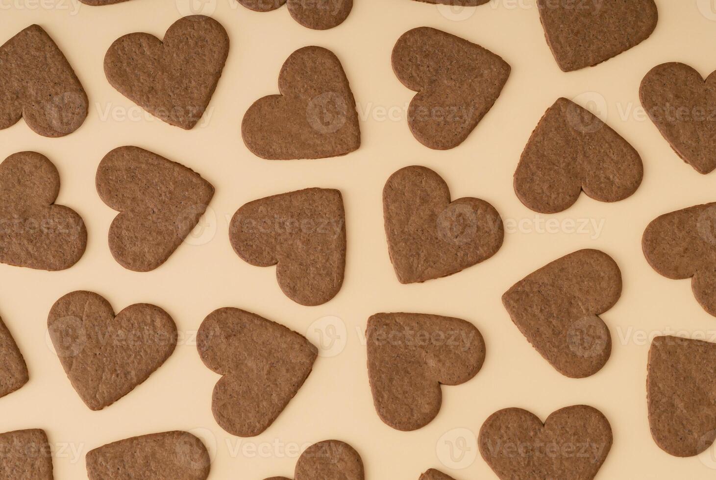 Trendy pattern made of heart shaped cookies on cream background. Minimal love layout. Creative biscuits idea. Yummy sweet food backdrop. Valentines day concept. Cookies aesthetic. Romantic flat lay. photo
