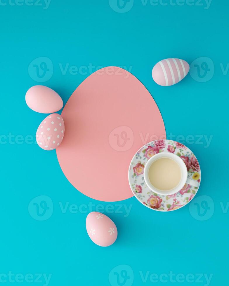Pink colored Easter eggs and floral cup of coffee with egg shaped paper card note copy space on light blue background. Minimal Easter concept. Creative festive spring holiday layout. Flat lay style. photo