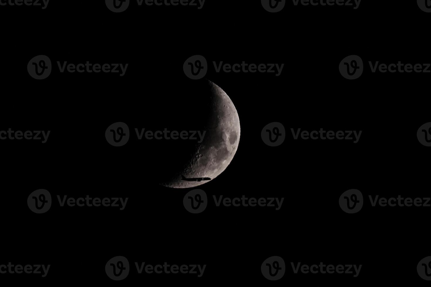 Silhouette of an Airplane in front of Moon photo
