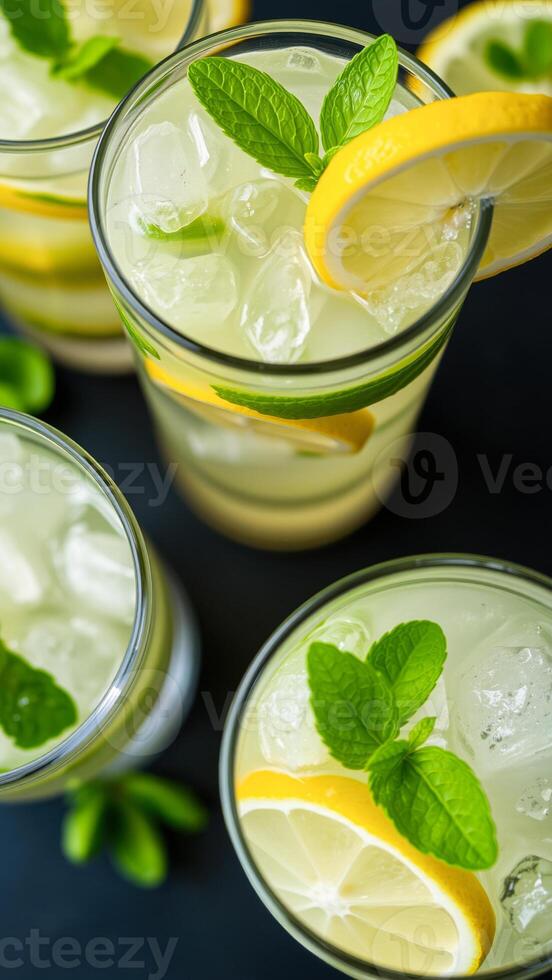 four glasses of refreshing lemonade with lemon slices and mint photo