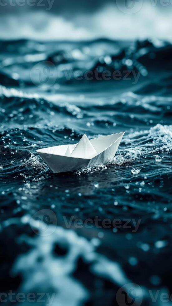small white paper boat floats on dark blue water photo