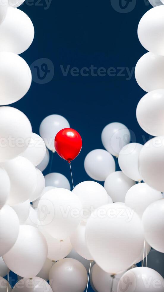 single red balloon stands out among many white balloons against a blue background photo