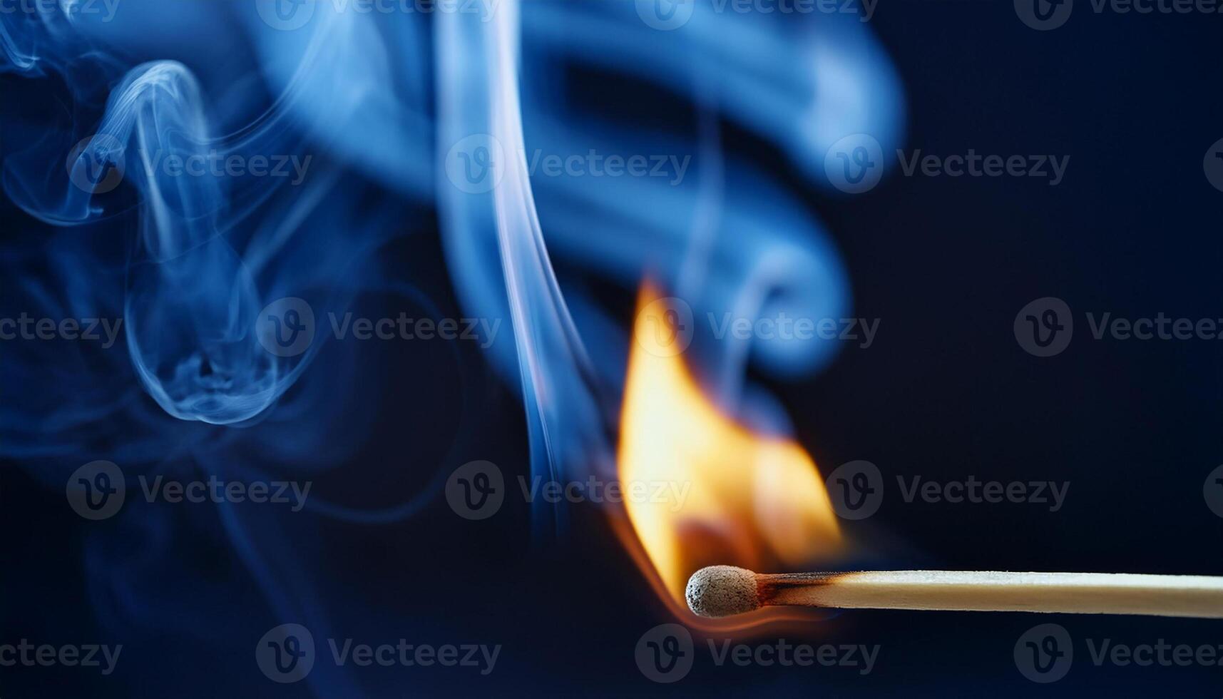 Burning match with bright flame and blue smoke on dark backdrop. photo