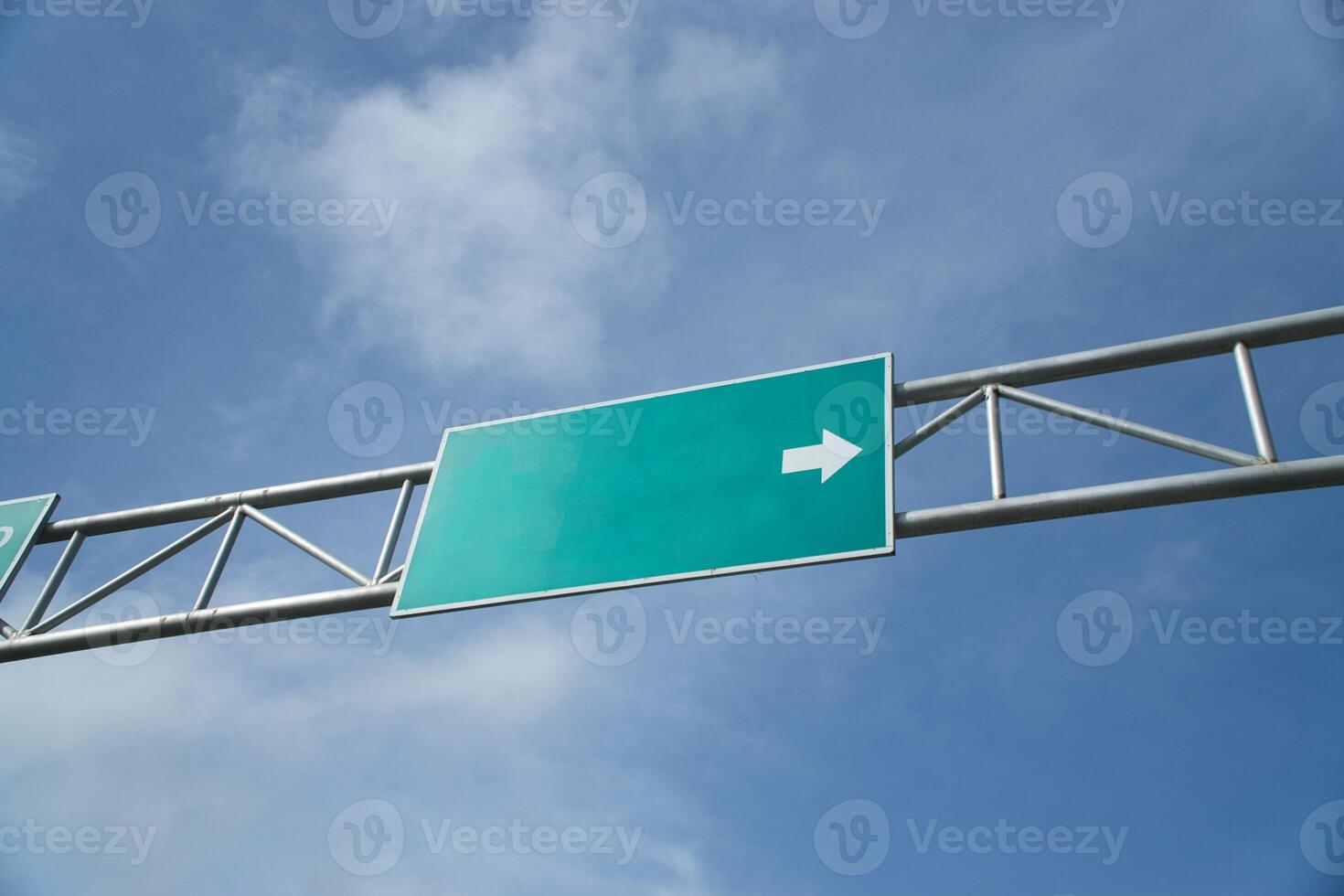 Blank Road Sign with an Arrow Beneath a Clear Blue Sky photo
