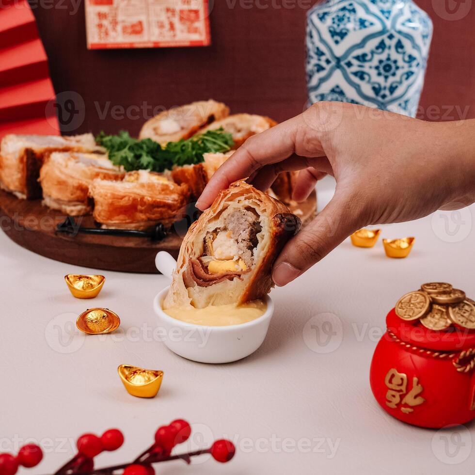 Ladies Hand Dipping Chinese New Years Food with Chinese Ornaments Background photo