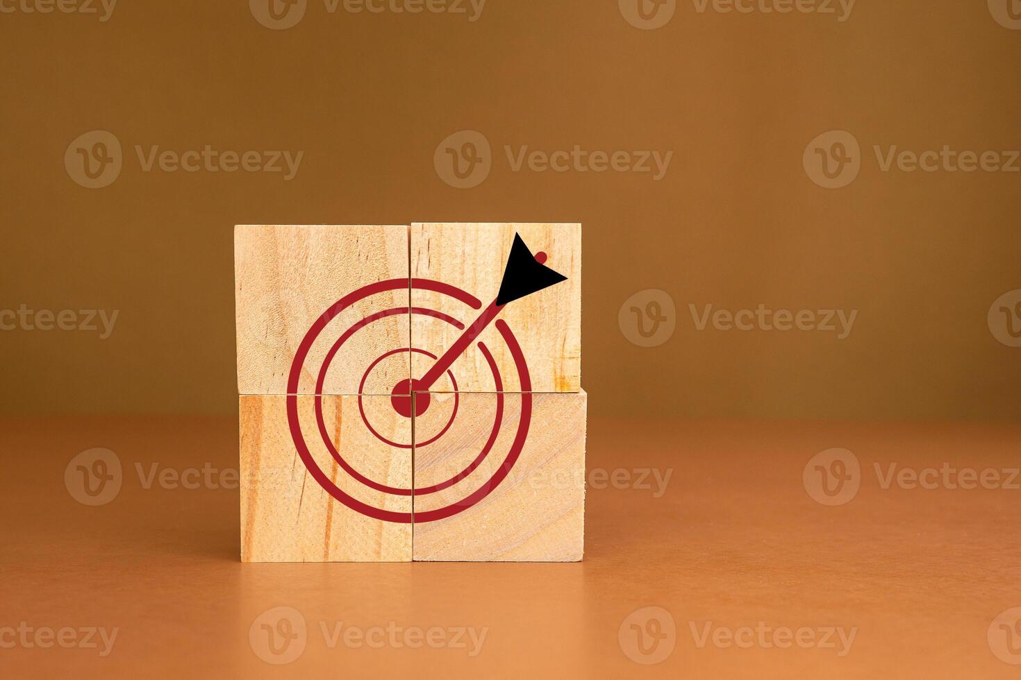 Focus on a goal and achieve a successful business. Darts target icons on wooden cubes against a brown background photo