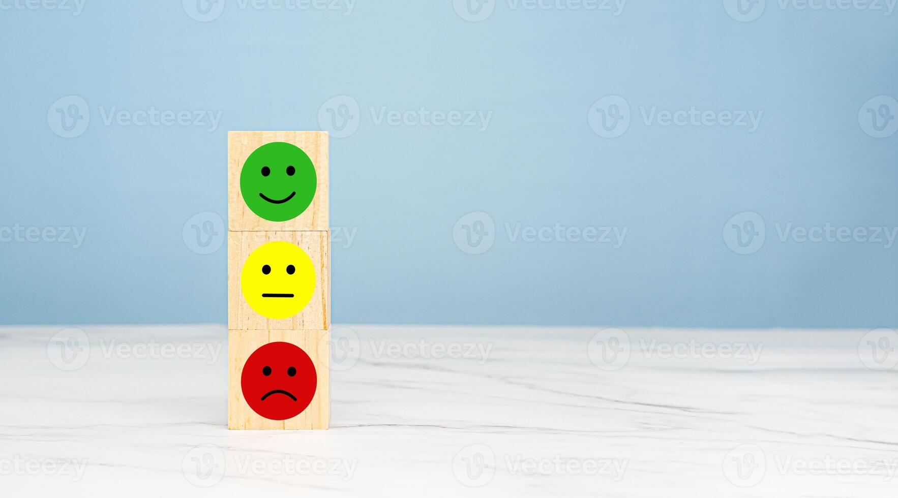 Satisfaction concept. Wooden cubes with green, yellow, and red mood icons on a table photo