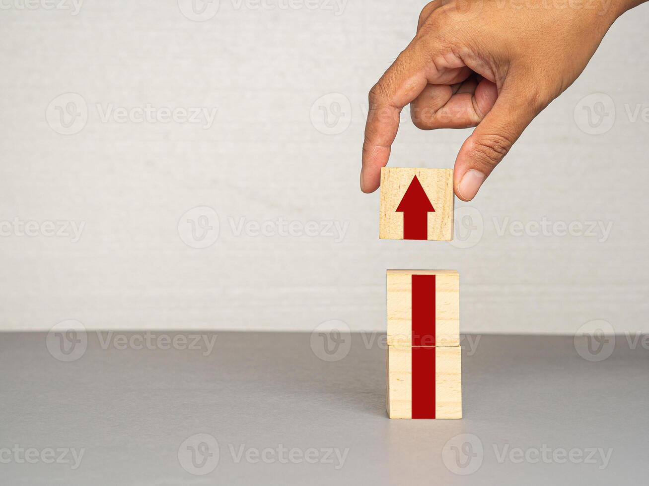 Business growth concept. Wooden cubes with red arrows up a point on a gray background photo