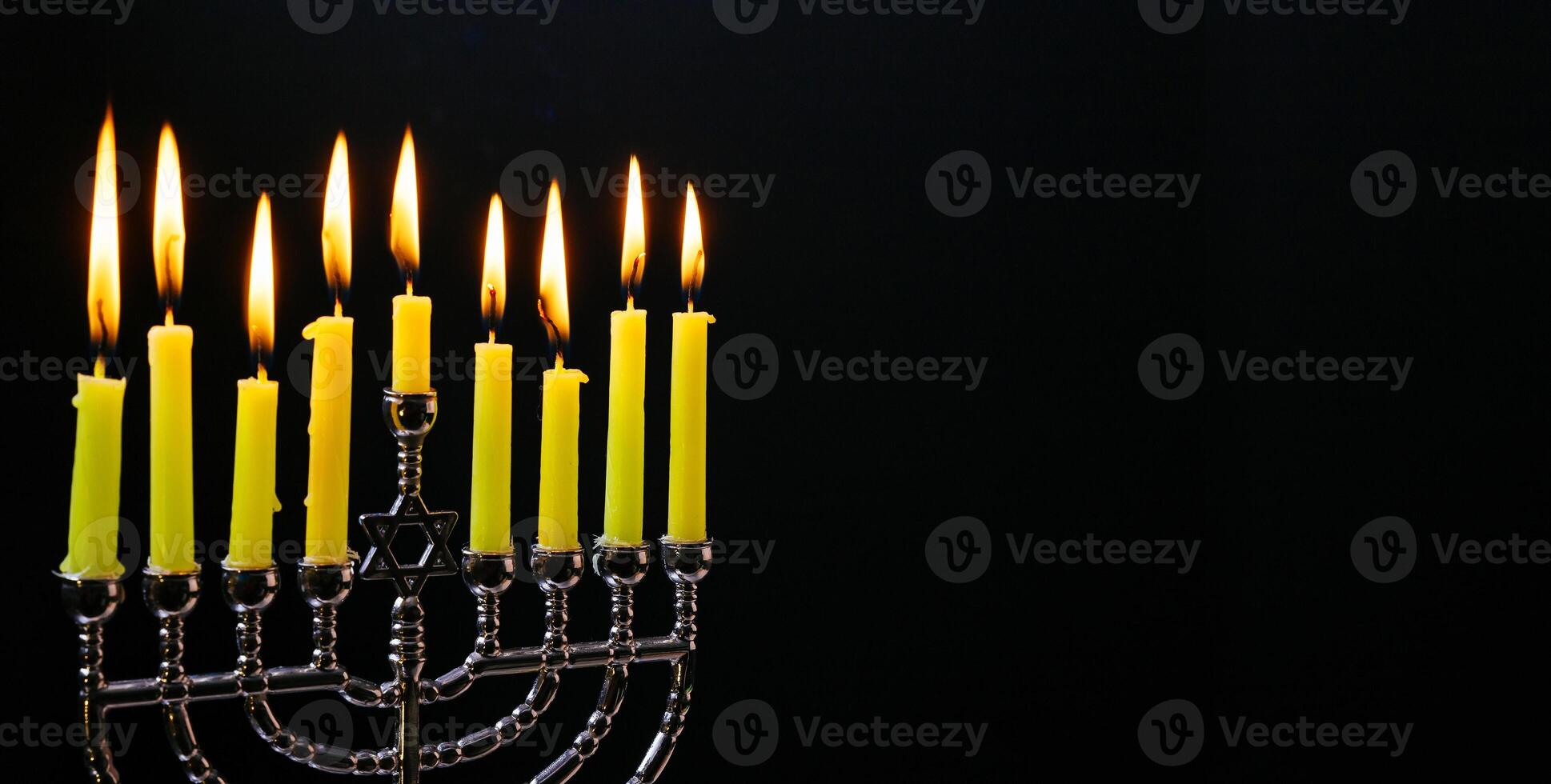 Jewish holiday hannukah low key image of jewish holiday Hanukkah with menorah traditional Candelabra and wooden dreidels spinning top . glitter overlay photo