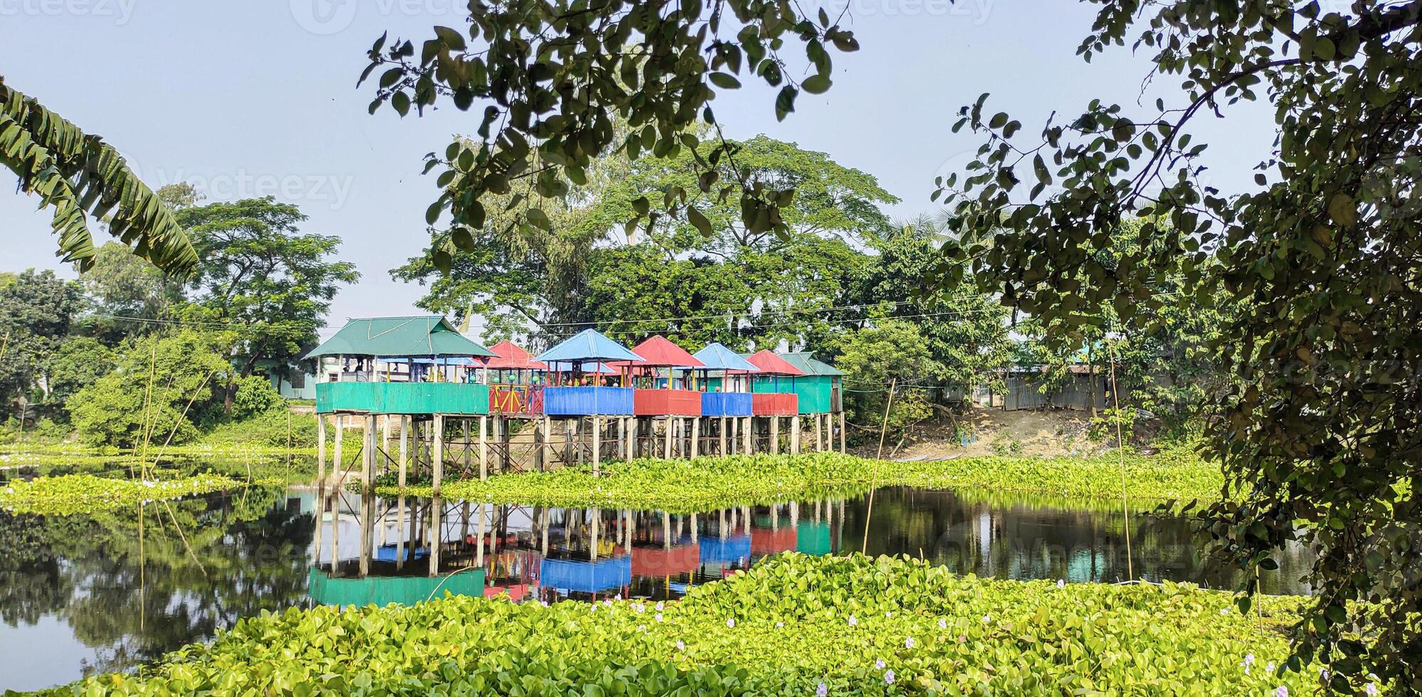 Houses on stilts by the lake, colorful houses on stilts in the middle of a lake, a small house sitting on stilts in the middle of a lake, photo