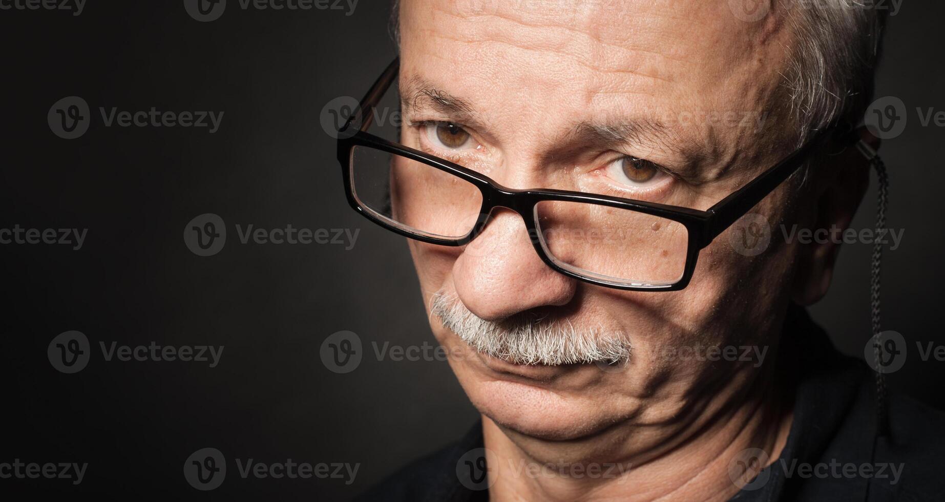 An older man with glasses and a mustache photo