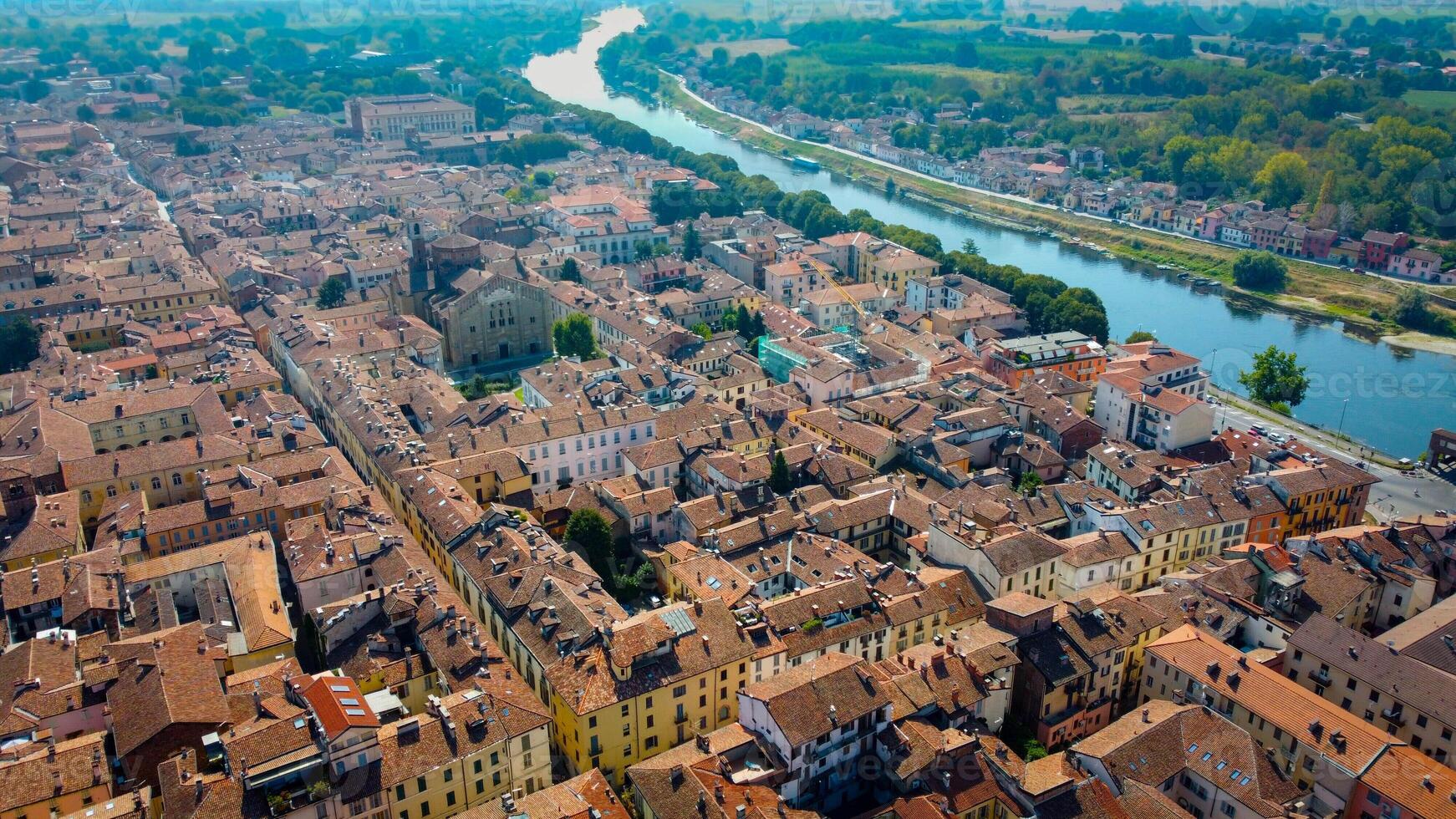 Aerial view of Pavia, Italy, Lombardy. Cattedrale di Santo Stefano e Santa Maria Assunta e Ticino river. Duomo di Pavia and covered bridge by drone, italian architecture. photo