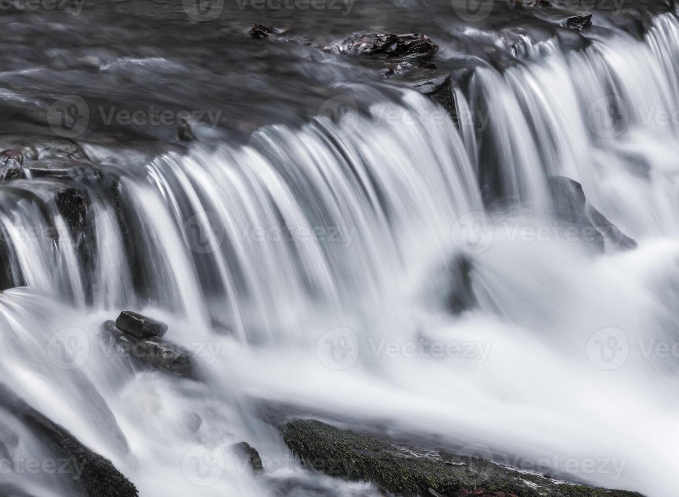 A person is standing on a rock in the water photo