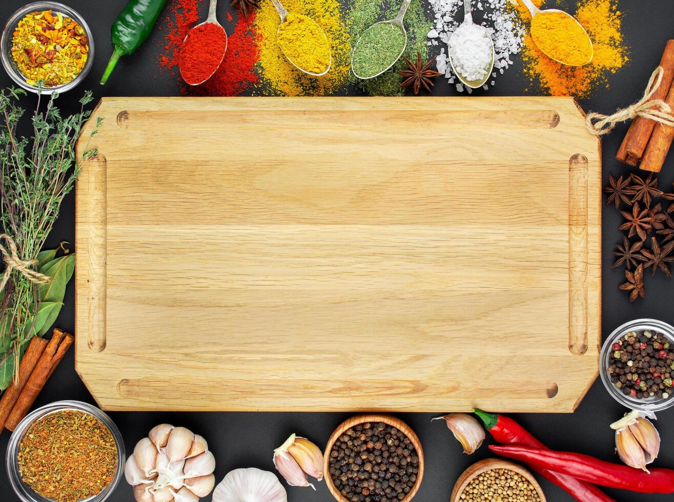 A variety of spices and herbs on a dark table. Cooking background. View from above. Ingredients for cooking. Table background menu. Copy space. photo