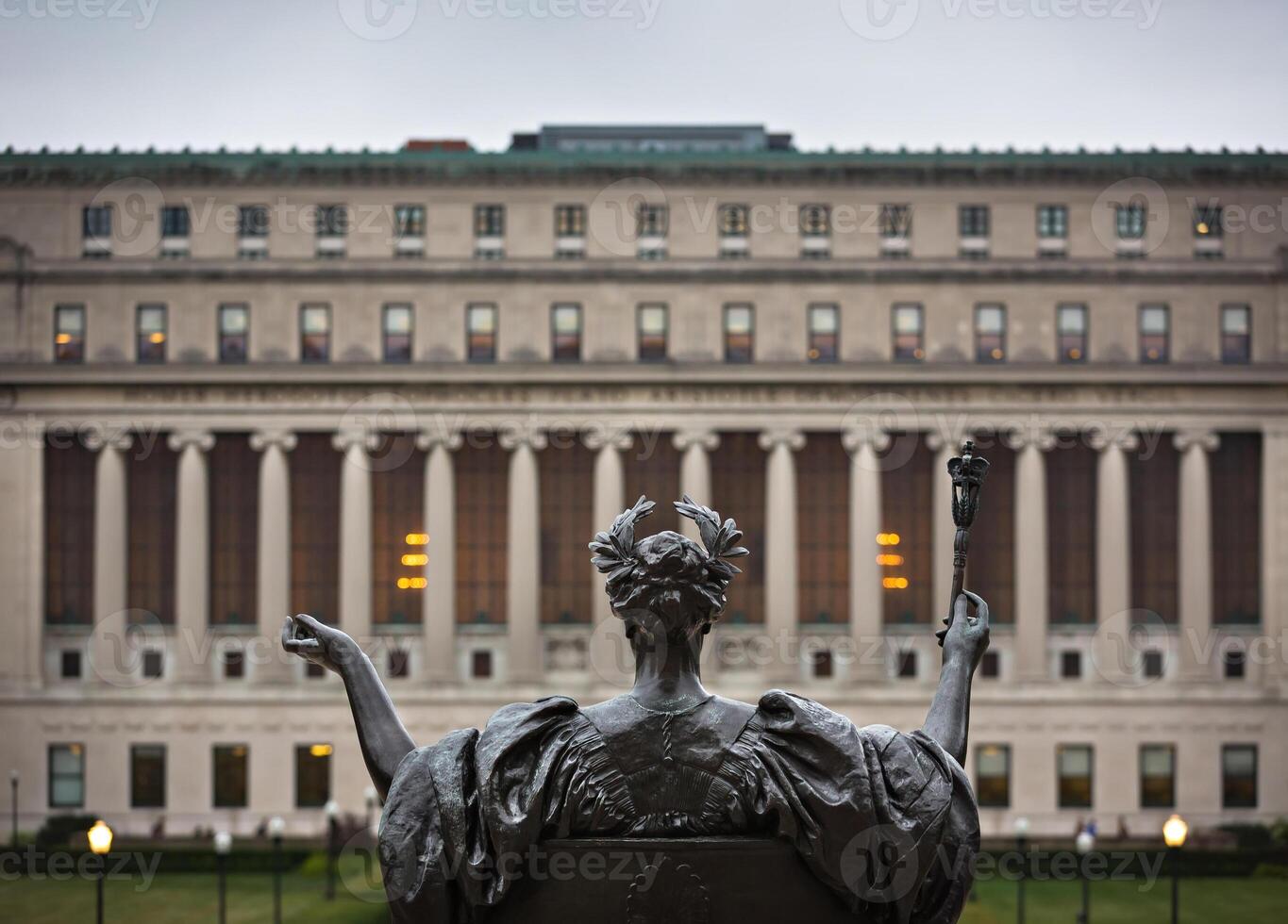 A statue of a woman holding a torch in front of a building photo