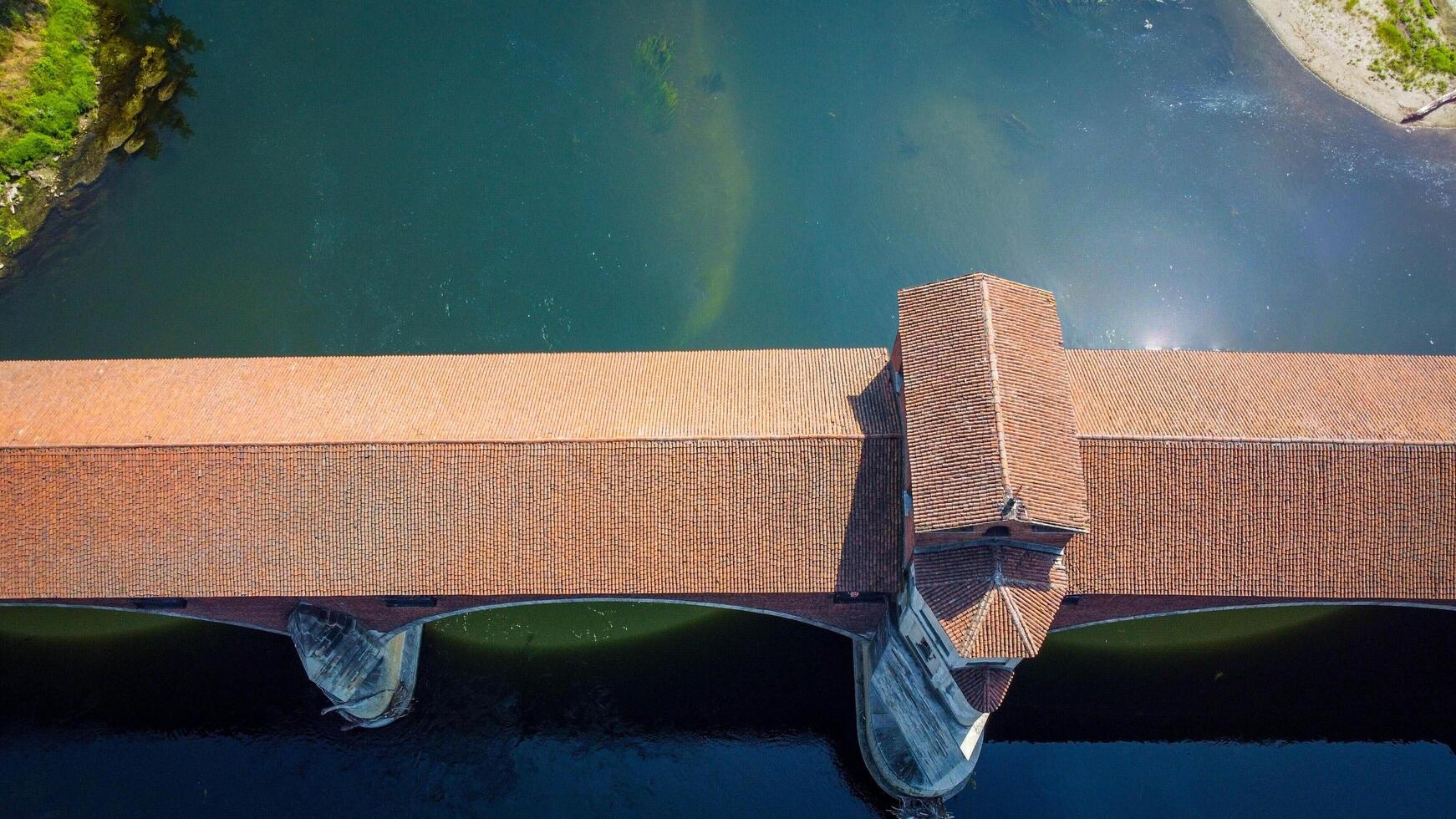 Pavia covered bridge, seen from a drone. Ponte coperto crosses the Ticino river, symbolic architecture of the city of Pavia, Lombardia, Italy. photo