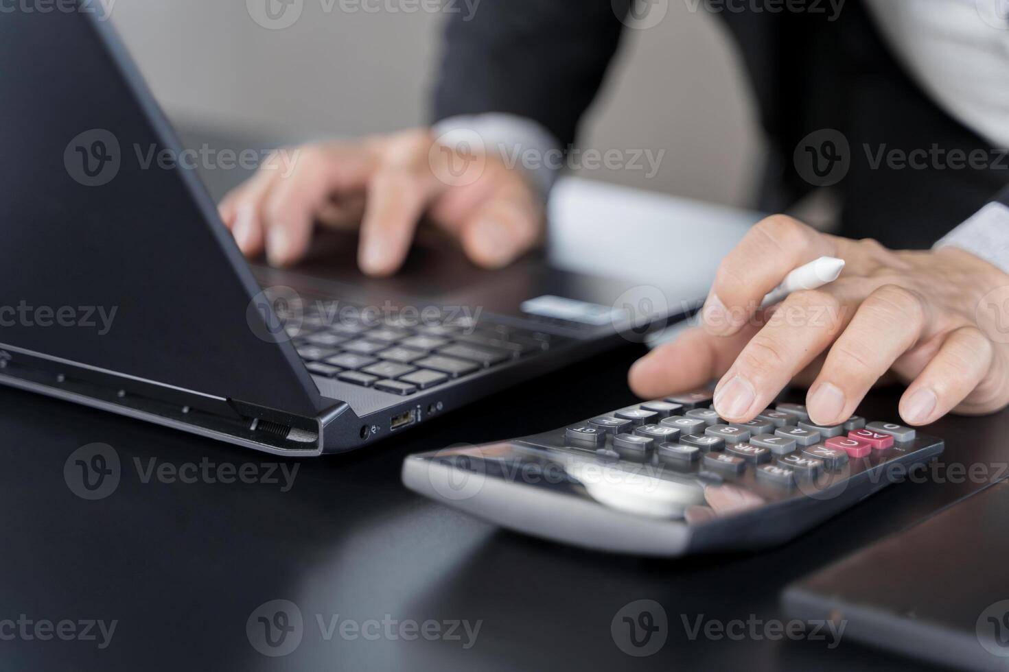Close up businessman hand using calculator to calculate home finance and writing note, accounting on table. photo